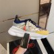 Versace Chain Reaction Trainer Handheld Side View in yellow and white Hand holding Versace Chain Reaction Baroque Pattern Chunky Sole Trainer showing side panel and lace details in yellow and white
