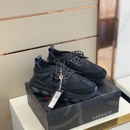 Pair of Versace Chain Reaction low top black trainers resting on branded box