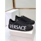 Versace Black Low Top Trainers Three-Quarter Angle in black and white Front-three-quarter view of Versace black leather trainers showing lace unit and side logo in black and white