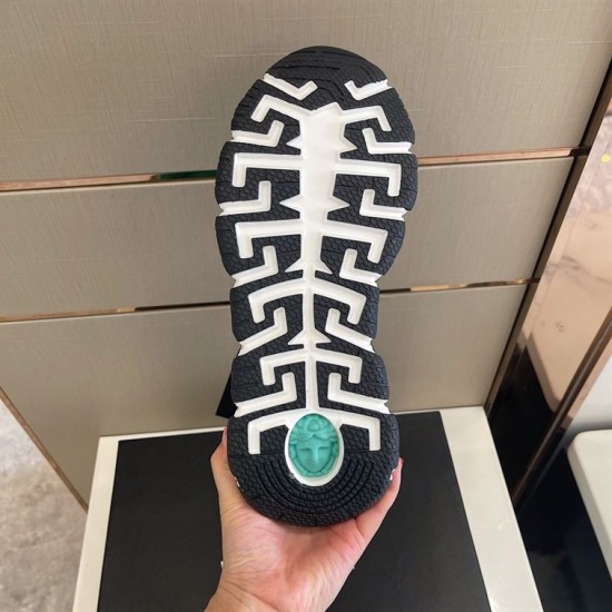 Underside view of Greek key sole pattern with green Medusa emblem in black and gold