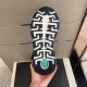 Underside view of Greek key sole pattern with green Medusa emblem in black and gold