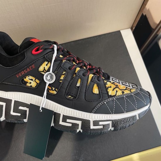 Close-up side detail of black upper, red logo, and gold pattern