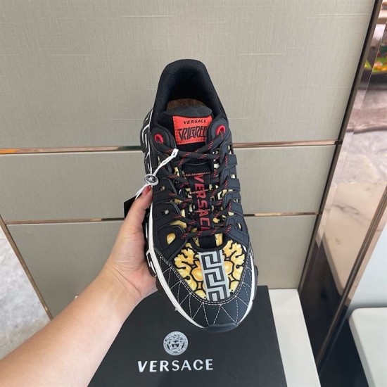 Top-down view of black lace cage and tongue patch on Versace trainer in black and gold