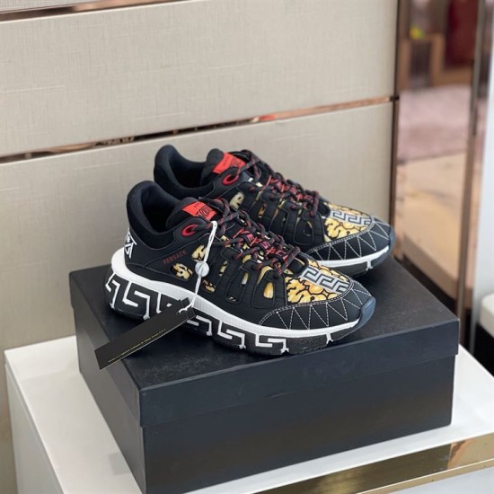 Pair of black and gold Versace Trigreca trainers on a shoe box