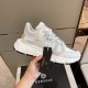 Versace Trigreca White Trainer Handheld in white and gold Hand holding white Versace Trigreca trainer with black product tag in white and gold