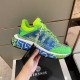 Hand holding the green and blue trainer showcasing side details and attached tags