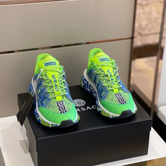 Front view of both green and blue trainers sitting on top of a black shoebox