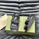 Angled top view of Gucci black and grey denim sandals displayed alongside a branded presentation box