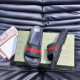 Gucci Slide Sandals Overhead View on Box in black and red Top-down view of black Gucci rubber slide sandals resting on a patterned green box alongside a dust bag in black and red