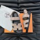 Hermes Suede Flat Sandals In Beige Angular View in beige and black Hermes beige and black flat sandals angled on top of branded packaging