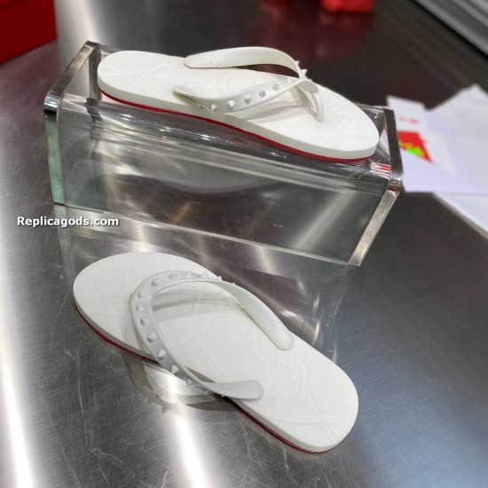 Christian Louboutin white spiked flat flip flop sandal pair arranged on metal surface
