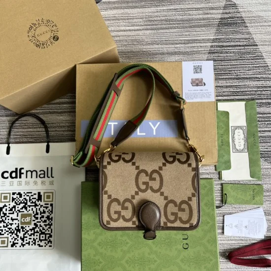 Men's Complete Presentation View with Packaging and Accessories Men's Flat lay showing the brown jumbo GG canvas shoulder bag alongside its packaging, boxes, and documentation