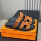 Hermes Brown Suede Sandals Angled View in brown and white Angled perspective of brown suede sandals placed on a branded box in brown and white