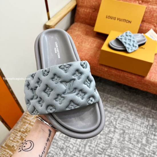 L Silver Pool Pillow Comfort Slides Detail View in silver and black Close-up hand-held view of the L silver Pool Pillow Comfort Slides highlighting the embossed monogram pattern in silver and black