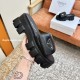 Prada Black Slide Handheld View Handheld angle of Prada black slide displaying the thick lug sole and side branding